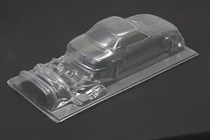 Unpainted clear polycarbonate RC car body shell for a Mazda Eunos Roadster showing main body and molded accessories.
