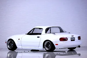 Rear three-quarter view of a white Pandora RC Mazda Eunos Roadster NA drift car body shell on a reflective surface.