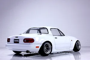 Rear three-quarter view of a white Pandora RC Mazda Eunos Roadster NA RC body shell with detailed tail lights, exhaust tip, and deep dish wheels.