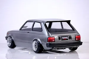 Rear three-quarter view of a grey Pandora RC Toyota Starlet KP61 body shell mounted on an RC chassis with deep dish wheels.