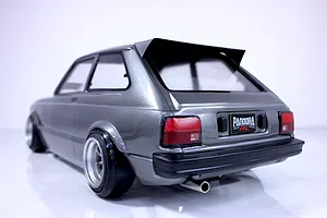 Rear-three-quarter view of a metallic grey Pandora RC Toyota Starlet KP61 radio-controlled drift car body mounted on a chassis with deep dish wheels.
