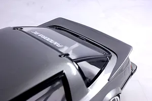 Close-up rear quarter view of a grey Pandora RC Mazda Savanna RX-7 body shell showcasing the hatch and spoiler.