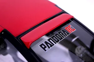 Close-up of a red RC car body roof and rear window section featuring a Pandora RC logo sticker.