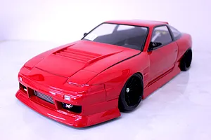 Front three-quarter view of a red Pandora RC 180SX drift car body shell mounted on a chassis with black wheels.