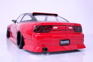 Rear three-quarter view of a painted red Pandora RC drift car body with black wheels and exhaust tip on a white surface.