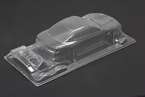 Unpainted clear polycarbonate RC drift car body shell viewed from the rear three-quarter angle against a dark background.