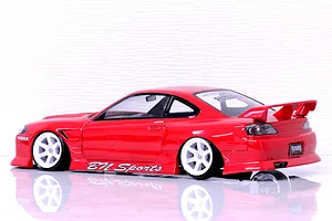 Side view of a red Pandora RC S15 Silvia BN Sports body shell on a white reflective surface against a textured white wall.