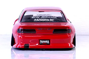 Rear view of a red Pandora RC S13 Silvia drift body shell featuring BN Sports decals and tinted taillights on a reflective white surface.