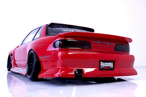 Rear three-quarter view of a red RC drift car body shell with BN Sports styling, black wheels, and a Pandora RC license plate against a white background.