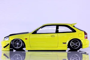 Side profile of a yellow Pandora RC Honda Civic EK9 Type-R body shell mounted on an RC chassis against a white background.