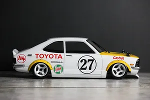 Side profile of a painted Toyota Corolla Levin TE27 RC body shell with racing liveries, number 27, and white wheels on a grey surface.