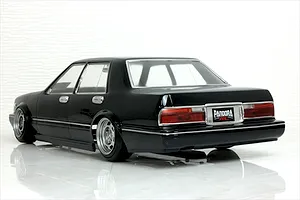 Rear-three-quarter studio shot of a black Pandora RC Y31 Cedric Sedan body shell mounted on an RC chassis with custom wheels.