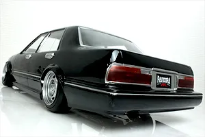 Rear quarter angle view of a black Pandora RC Y31 Cedric Sedan drift body shell with chrome trim and custom deep-dish wheels.