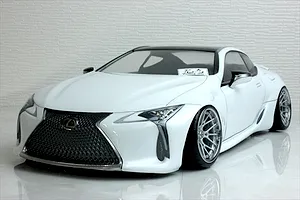 Front three-quarter view of a painted white RC drift car body shell modeled after a Lexus LC with custom wheels and a black roof.