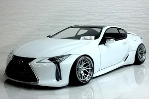 Front three-quarter view of a white Lexus RC drift RC car body shell with chrome mesh grille and custom mesh wheels on a glossy white surface.