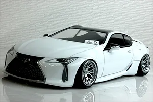 White Lexus RC drift car body shell with a black roof, custom multi-spoke wheels, and detailed front grille parked on a reflective surface.