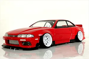Red RC drift car body styled as an S14 Silvia with white deep-dish wheels, displayed on a glossy white surface.