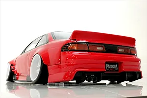 Rear three-quarter view of a red RC drift car body styled as an S14 Silvia with white wheels, aggressive rear bumper, and dual exhaust.
