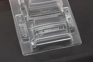 Unpainted clear polycarbonate RC car body shell with additional molded parts on a dark background.