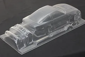 Unpainted clear polycarbonate RC drift car body shell with separate bumper and parts molded on a single sheet.
