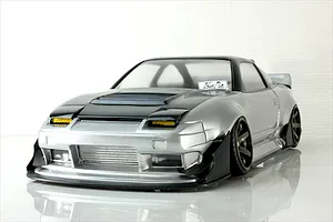 Front three-quarter view of a silver and black RC drift car body shell on a reflective white studio surface.