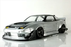 Silver and black RC drift car body shell styled after a customized Nissan 180SX parked on a reflective white studio surface.
