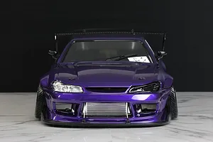 Front view of a purple RC drift car body shell with a detailed intercooler and aggressive styling on a marble surface.