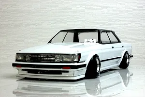 Painted white RC drift car body shell mounted on a chassis with wide wheels, sitting on a reflective white surface.