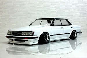 A painted white RC drift car body shell mounted on a chassis with custom wheels against a textured background.