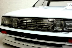 Close-up front view of a white RC car body shell showing the grille, headlights, and bumper detail.