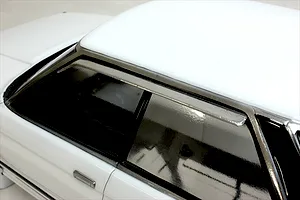 Close-up view of the side windows, roof, and door handle on a white RC car body shell.