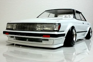 Front view of a white RC drift car body styled like a Toyota Mark 2 GX71 on a reflective surface.