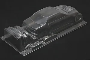 Unpainted clear polycarbonate RC car body shell for Toyota Chaser JZX100 on a dark background.