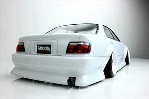 Rear three-quarter view of a white Toyota Chaser JZX100 RC drift car body with Pandora RC license plate and custom exhaust.