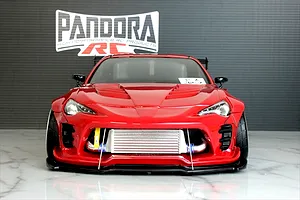 Front view of a red RC drift car body styled as a Toyota 86 with BN Sports kit, featuring an intercooler and Pandora RC logo in background.