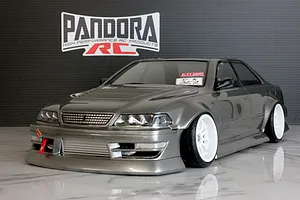 Painted grey RC drift car body shell of a Toyota Mark II JZX100 with white deep dish wheels and front tow strap, displayed in front of a Pandora RC wall logo.