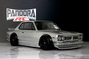 Silver Pandora RC KPGC10 Skyline GT-R body shell mounted on a chassis with black wheels against a black backdrop.