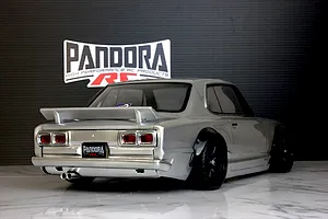 Rear three-quarter view of a silver Pandora RC KPGC10 Skyline GT-R body shell mounted on an RC chassis with a Pandora RC logo in the background.