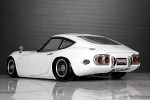 Rear three-quarter view of a white Pandora RC Toyota 2000GT RC drift car body on a reflective surface.