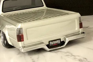 Rear view of silver Toyota Hilux RN80 RC body shell featuring chrome bumper, tail lights, and Pandora RC license plate on a marble surface.