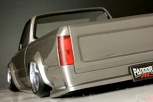 Rear quarter angle of the painted Pandora RC Toyota Hilux RN80 body shell showing the tailgate, taillight, and stance.