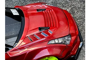 Close-up of the red painted bonnet and front fender vents on a Pandora RC body shell, outdoor setting.