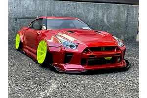 Custom painted red RC drift car body on an R35 GT-R with bright yellow wheels, parked on asphalt.