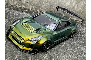 A painted green and gold Pandora RC R35 GT-R BN-Sports drift car body shell mounted on an RC chassis outdoors on concrete.