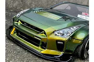 Close-up front angle of a custom painted metallic green and gold Nissan GT-R RC drift car body shell sitting outdoors.