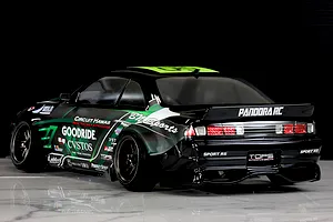 Rear three-quarter view of a Pandora RC S14 Silvia RC drift car featuring a black body with green and white sponsor decals.