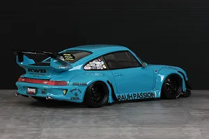 Rear three-quarter view of a light blue Pandora RC RWB 993 body shell with wide fenders, black wheels, and custom sponsor decals.