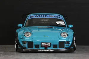 Front view of a blue Pandora RC RWB 993 type body shell with wide fenders and decals on a dark background.