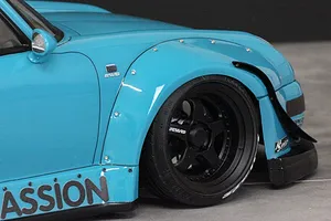 Close-up view of the front fender, wheel, and side detail of a light blue Pandora RC RWB 993 type body shell.