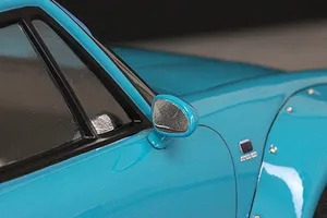 Close-up view of a blue RC car body shell showing the side mirror, window frame, and fender flare.